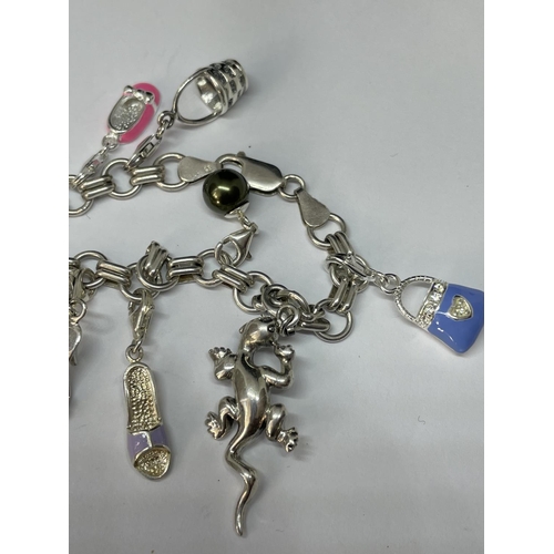 611 - A SILVER CHARM BRACELET WITH TWELVE VARIOUS CHARMS