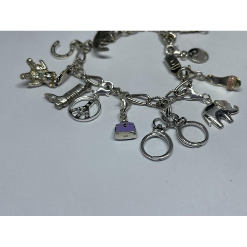 638 - A SILVER CHARM BRACELET WITH THIRTEEN CHARMS