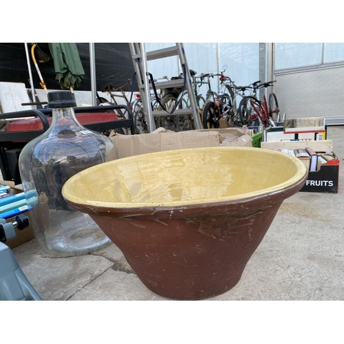 1463 - A LARGE CLEAR GLASS CARBOYD AND A LARGE GLAZED PLANTER