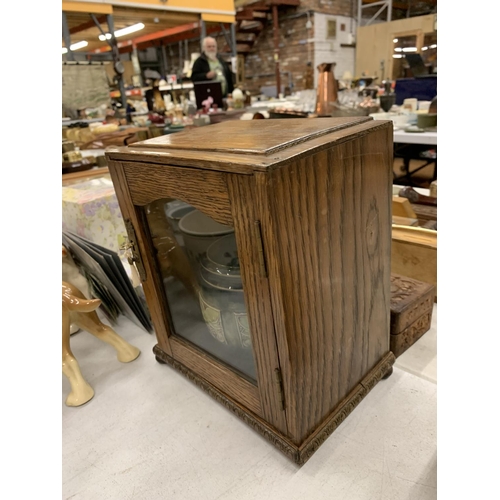 205 - A VINTAGE OAK TOBACCO CABINET WITH GLASS FRONT AND KEY TO INCLUDE A ROYAL DOULTON TOBACCO JAR - A/F ... 