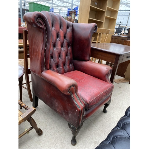 2277 - AN OXBLOOD WINGED BUTTON-BACK FIRESIDE CHAIR, ON CABRIOLE LEGS