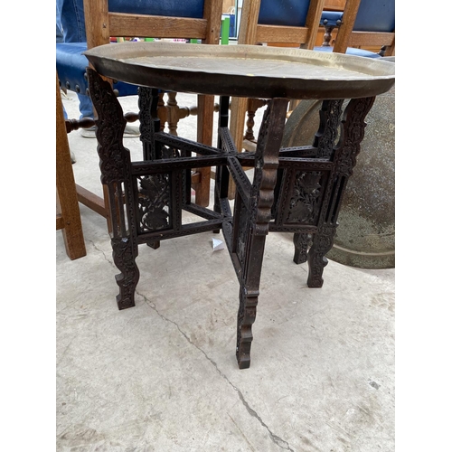 2408 - A 19TH CENTURY INDIAN HARDWOOD FOLDING HEAVILY CARVED TABLE WITH BRASS TOP, COMPLETE WITH ONE OTHER ... 