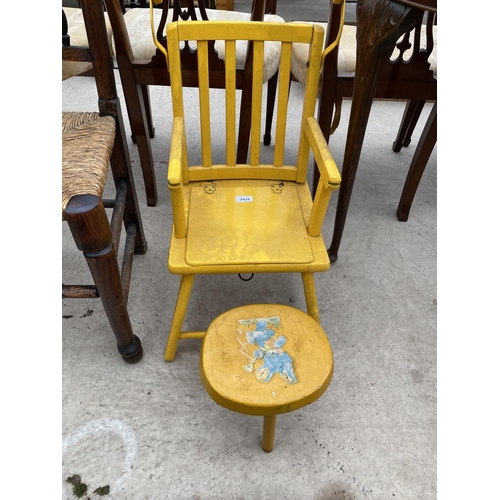 2435 - A BRIGHT YELLOW CHILDS CHAIR WITH FOLD-DOWN TRAY AND SMALL STOOL DECORATED WITH TEDDY BEAR