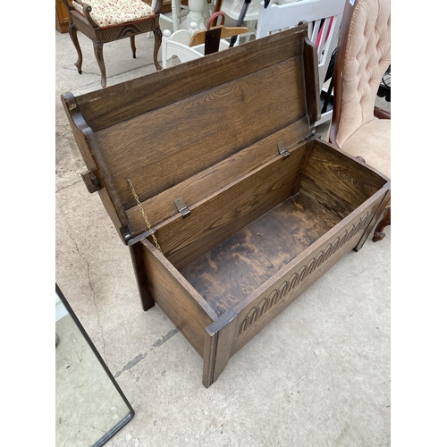 2451 - A REPRODUCTION OAK BLANKET CHEST WITH CARVED FRONT PANEL, 41