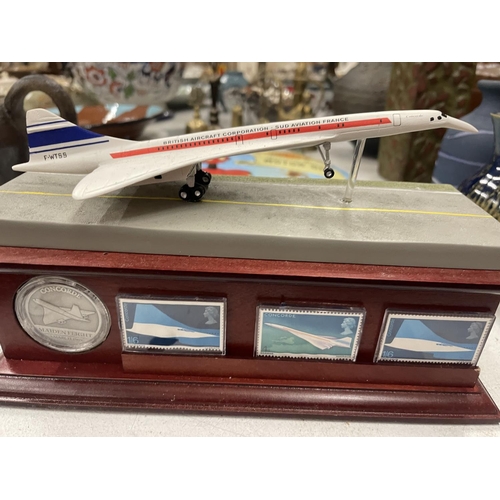 258 - A HAND-PAINTED SCULPTURE OF CONCORDE ON A WOODEN PLINTH WITH MINT CONDITION ROYAL MAIL STAMPS AND EX... 