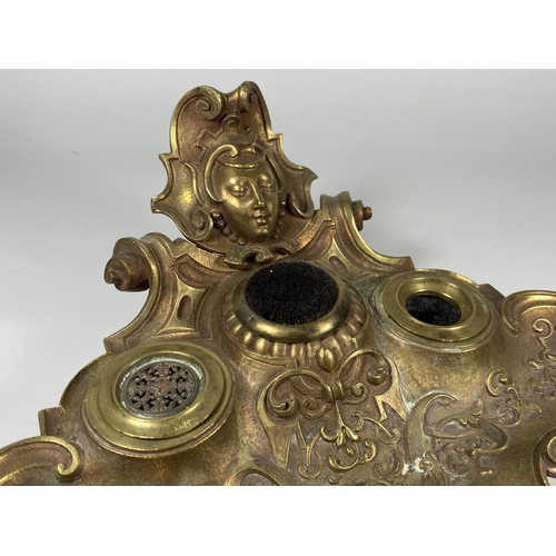 26 - AN ART NOUVEAU BRASS INKSTAND WITH LADIES HEAD DESIGN TOP, (MISSING ONE INKWELL)