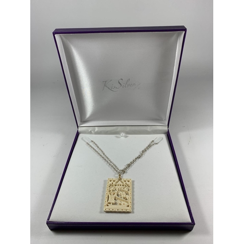 686 - A BOXED SILVER NECKLACE WITH CARVED PENDANT