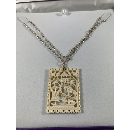 686 - A BOXED SILVER NECKLACE WITH CARVED PENDANT