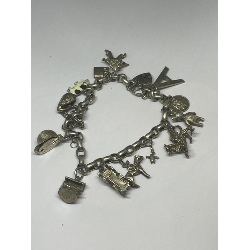 702 - A VINTAGE SILVER CHARM BRACELET WITH FOURTEEN CHARMS