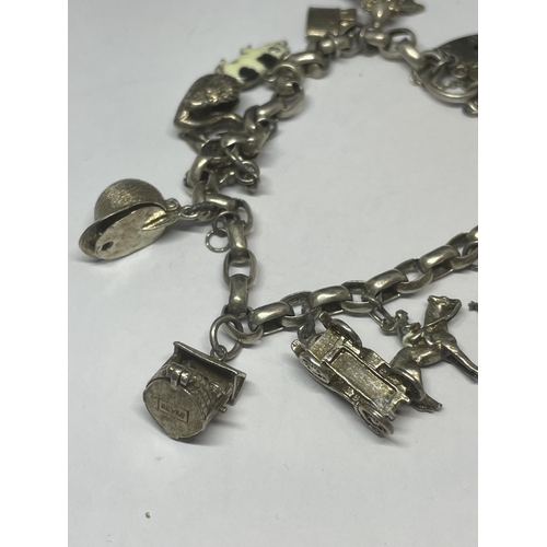 702 - A VINTAGE SILVER CHARM BRACELET WITH FOURTEEN CHARMS