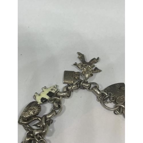 702 - A VINTAGE SILVER CHARM BRACELET WITH FOURTEEN CHARMS