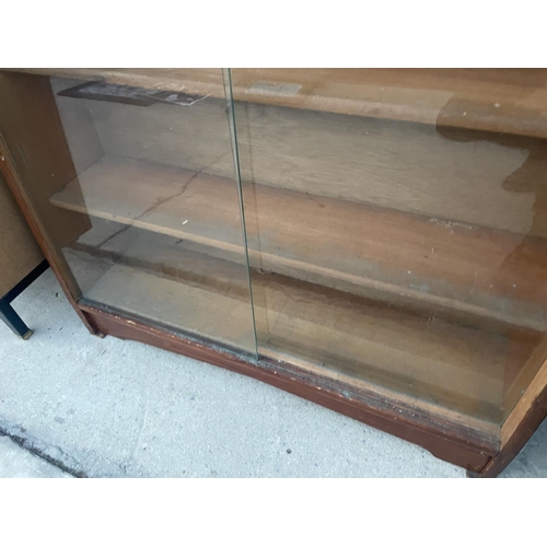 2672 - A HERBERT E GIBBS MID 20TH CENTURY BOOKCASE WITH TWO SLIDING GLASS DOORS - 35