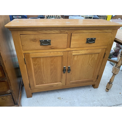 2545A - A MODERN OAK SIDEBOARD ENCLOSING TWO DRAWERS AND CUPBOARDS