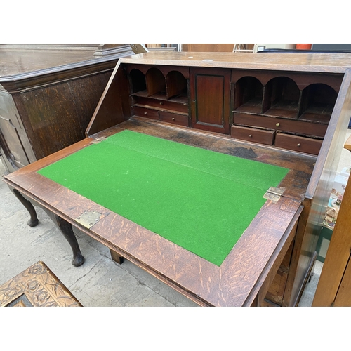 2545B - A GEORGE III OAK AND CROSSBANDED BUREAU WITH FITTED INTERIOR, FOUR GRADUATED DRAWERS ON BRACKET FEET... 