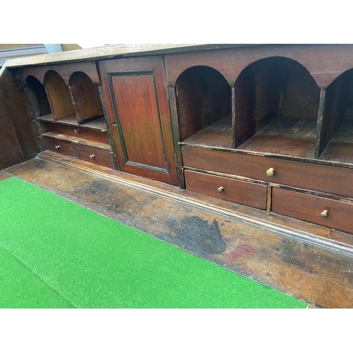 2545B - A GEORGE III OAK AND CROSSBANDED BUREAU WITH FITTED INTERIOR, FOUR GRADUATED DRAWERS ON BRACKET FEET... 