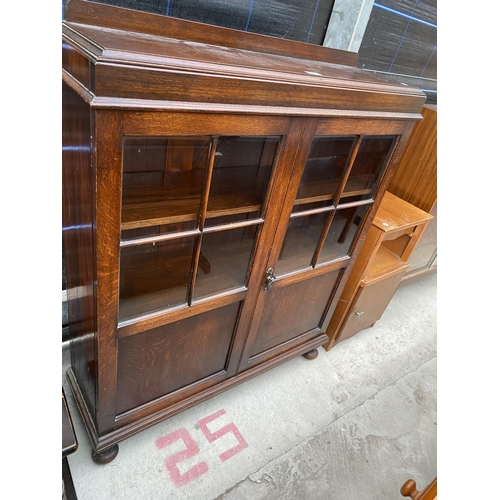 2571 - AN EARLY 20TH CENTURY OAK GLAZED TWO DOOR CABINET ON BUN FEEET, 36