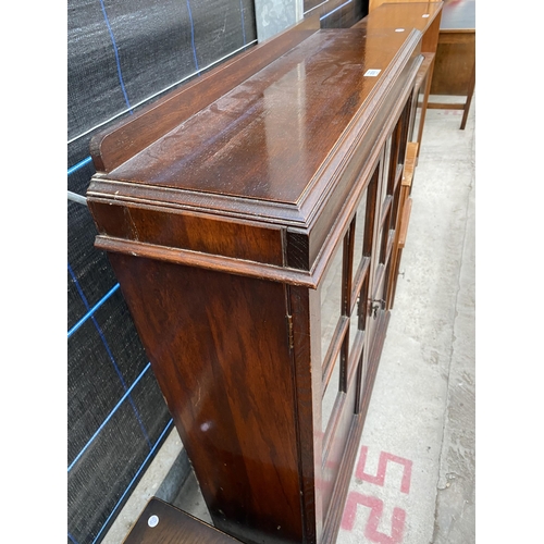 2571 - AN EARLY 20TH CENTURY OAK GLAZED TWO DOOR CABINET ON BUN FEEET, 36