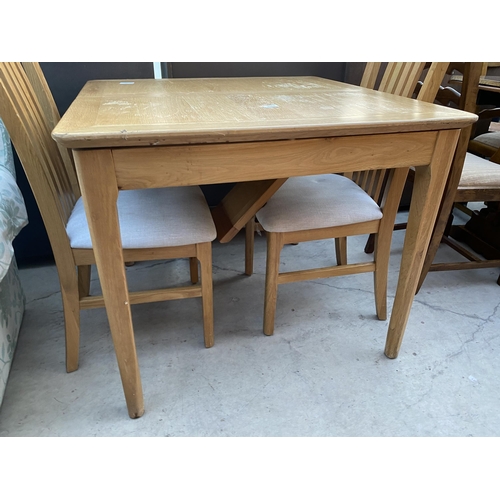 2585 - A MODERN OAK EXTENDING DINING TABLE AND TWO CHAIRS