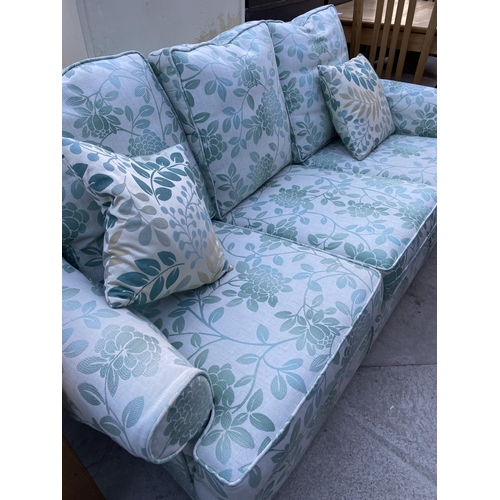 2586 - A MODERN GREEN FLORAL THREE SEATER SETTEE COMPLETE WITH ANTIMACASSARS