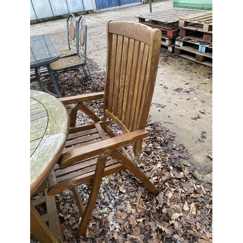 1634 - AN OVAL TEAK GARDEN TABLE AND SIX FOLDING TEAK CHAIRS, TWO BEING CARVERS