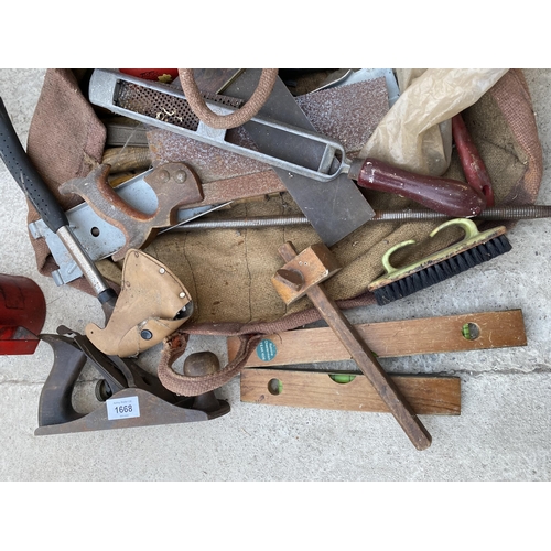 1668 - AN ASSORTMENT OF TOOLS TO INCLUDE A WOOD PLANE, AN AXE AND OIL CANS ETC