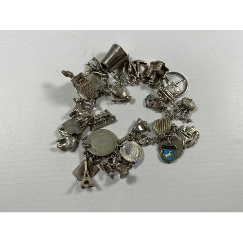 733 - A VINTAGE SILVER CHARM BRACELET AND ASSORTED CHARMS