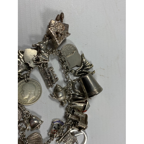 733 - A VINTAGE SILVER CHARM BRACELET AND ASSORTED CHARMS