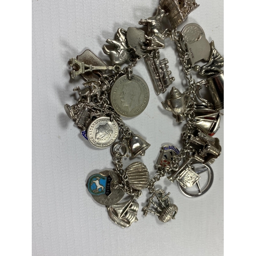 733 - A VINTAGE SILVER CHARM BRACELET AND ASSORTED CHARMS