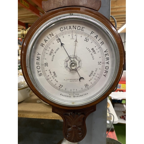 1045 - A MAHOGANY CASED ANEROID BAROMETER WITH CARVING TO THE TOP AND BOTTOM