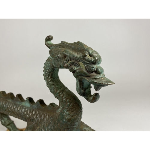 343 - A 19TH CENTURY CHINESE BRONZE MODEL OF A DRAGON ON CARVED WOODEN BASE, LENGTH 30CM