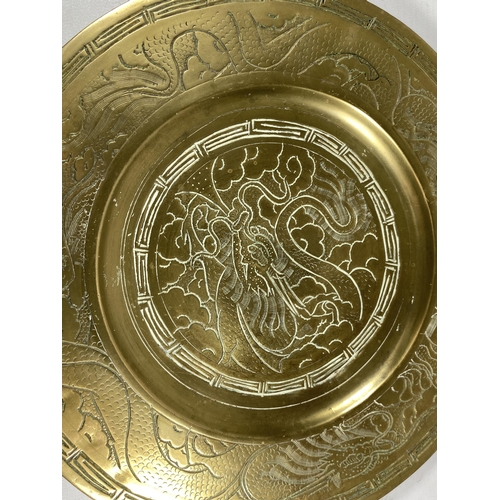 354 - A CHINESE BRASS CHARGER WITH DRAGON DESIGN, SEAL MARK TO REVERSE, DIAMETER 24CM