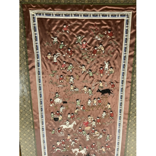 382 - A GILT FRAMED CHINESE SILK PICTURE OF FIGURES ON A RED SILK GROUND, 67 X 34CM