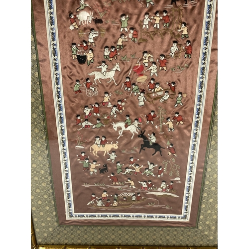 382 - A GILT FRAMED CHINESE SILK PICTURE OF FIGURES ON A RED SILK GROUND, 67 X 34CM