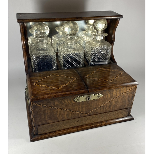 1 - AN EDWARDIAN INLAID OAK THREE BOTTLE TANTALUS HOLDER WITH TWIN LIDDED COMPARTMENT AND LOWER DRAWER W... 