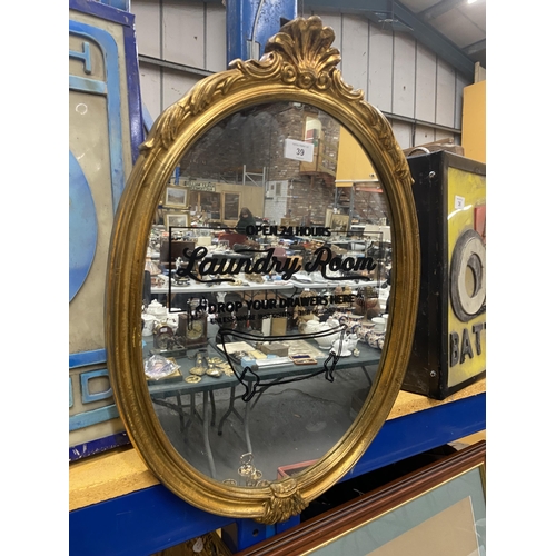 39 - AN OVAL GILT FRAMED 'LAUNDRY ROOM' DROP YOUR DRAWERS HERE MIRROR, HEIGHT 60CM