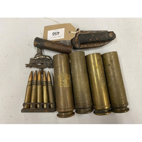 456 - FOUR BRASS BOFORS SHELL CASES, CLIP OF FIVE INERT BULLETS, LINCOLNSHIRE REGIMENT CAP BADGE AND A PEN... 