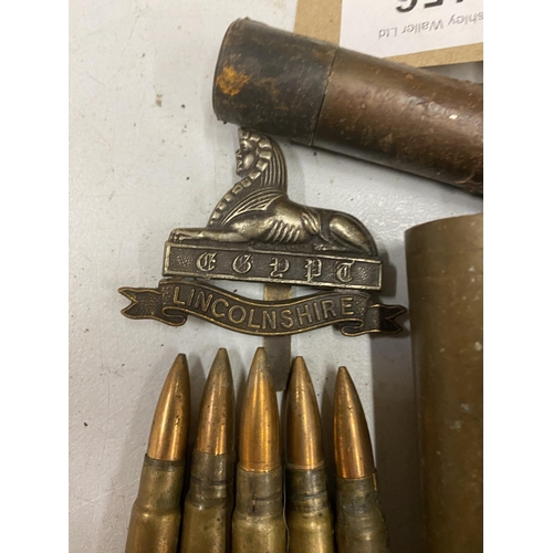 456 - FOUR BRASS BOFORS SHELL CASES, CLIP OF FIVE INERT BULLETS, LINCOLNSHIRE REGIMENT CAP BADGE AND A PEN... 