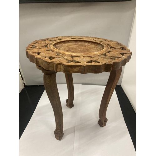 135 - AN ASIAN STYLE SMALL WOODEN TABLE WITH CARVED DECORATION HEIGHT 32CM