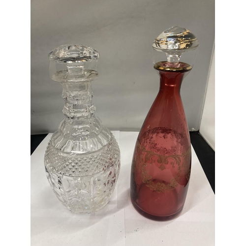 139 - TWO GLASS DECANTERS ONE BEING CRANBERRY WITH GILT DECORATION