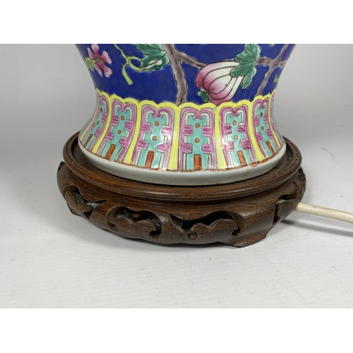 415 - A LARGE CHINESE ENAMEL DESIGN PEACH BLOSSOM TABLE LAMP ON CARVED WOODEN BASE, HEIGHT INCLUDING FITTI... 