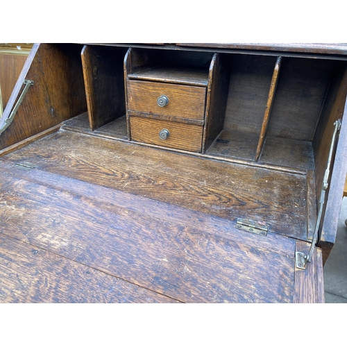 2698 - AN EARLY 20TH CENTURY OAK BUREAU ON BARLEY TWIST LEGS 30