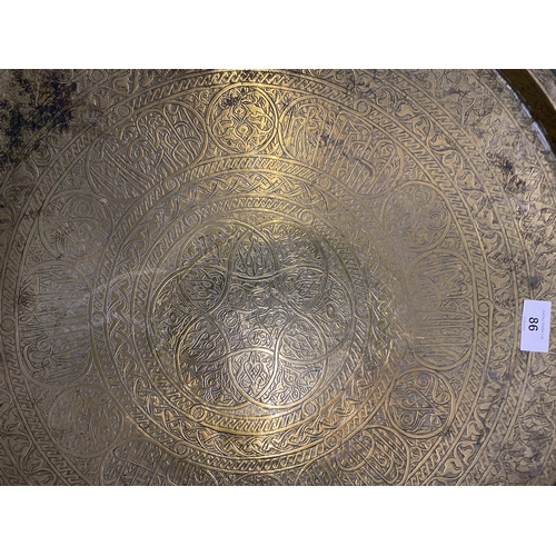 86 - A LARGE MIDDLE EASTERN BRASS CHARGER, DIAMETER 56CM