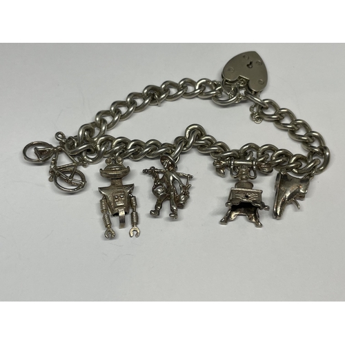 723 - A SILVER CHARM BRACELET WITH FIVE CHARMS