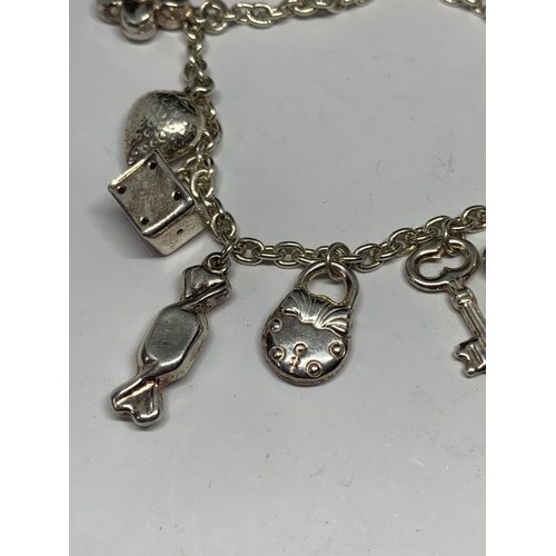 604 - A SILVER BRACELET WITH ELEVEN CHARMS