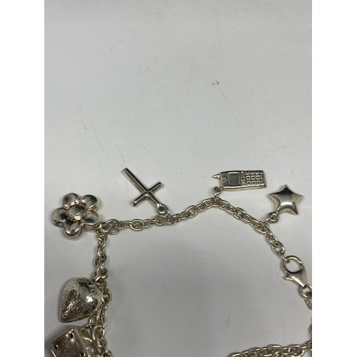 604 - A SILVER BRACELET WITH ELEVEN CHARMS