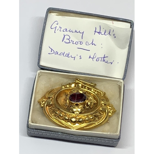 554 - A VICTORIAN GILT METAL AND GARNET STONE MEMORIAL BROOCH