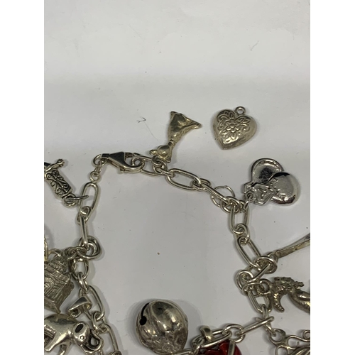 592 - A SILVER CHARM BRACELET WITH FOURTEEN CHARMS