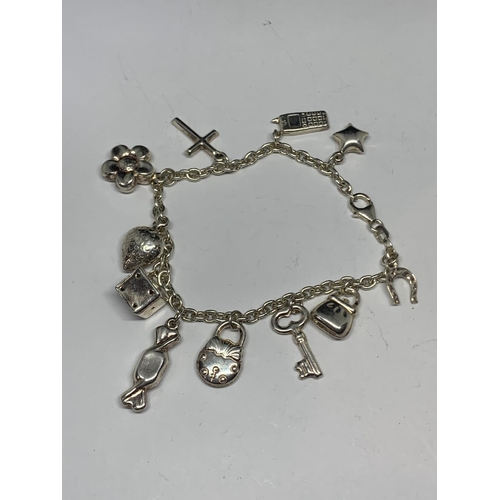 604 - A SILVER BRACELET WITH ELEVEN CHARMS