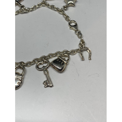 604 - A SILVER BRACELET WITH ELEVEN CHARMS