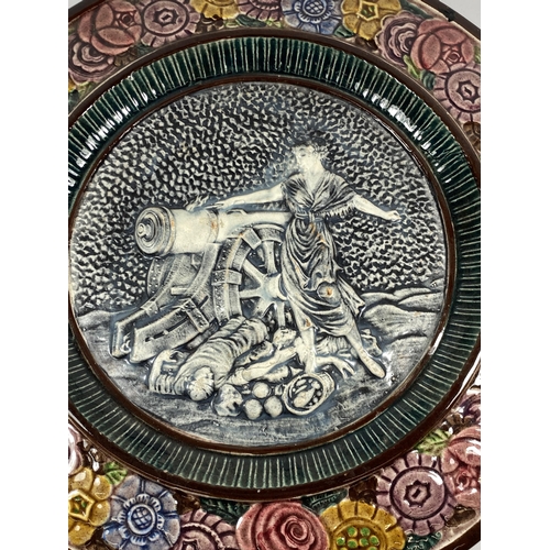 10 - A LARGE MAJOLICA STYLE FRENCH POTTERY CHARGER DEPICTING A LADY WITH CANNON, DIAMETER 43CM